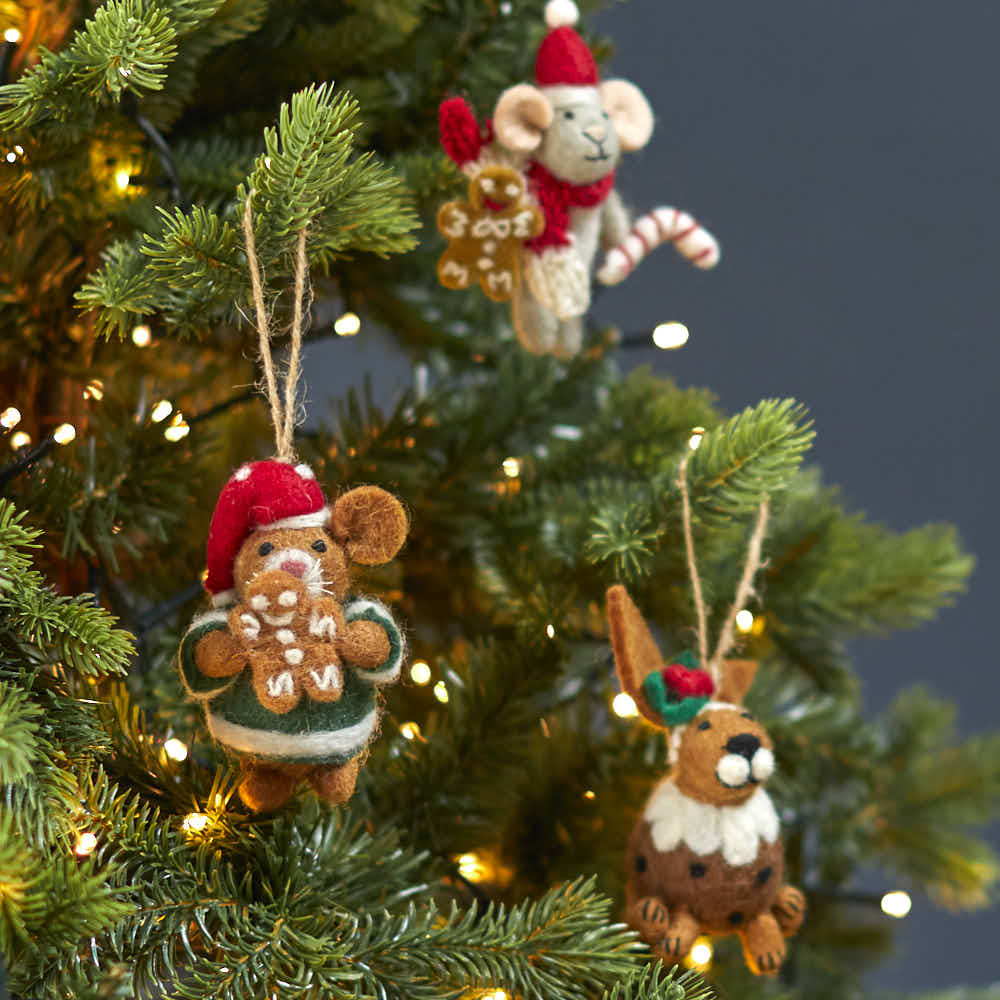 Handmade felt animal decorations including Harvey the Hamster hanging on a lit Christmas tree.