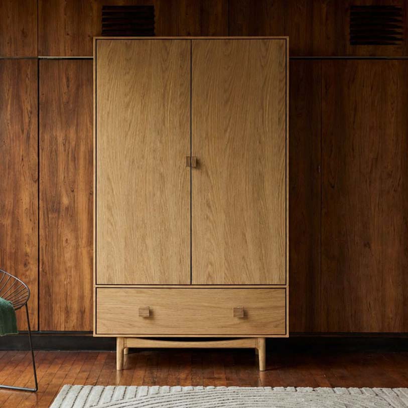 Lifestyle shot of the oak wardrobe in a mid-century styled bedroom with wood panelled walls