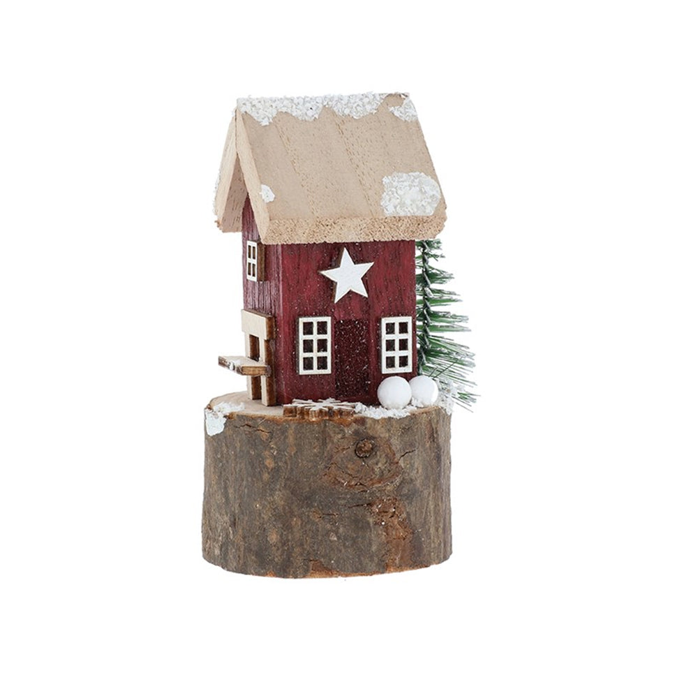 Red wooden folk art house with a white star and snow-dusted roof standing on a natural wood base.