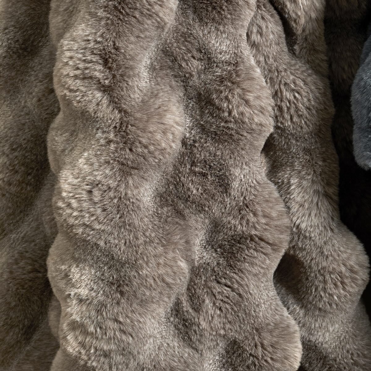 Close-up detail of the sheared brown faux fur showing the rippled, feather-like texture.