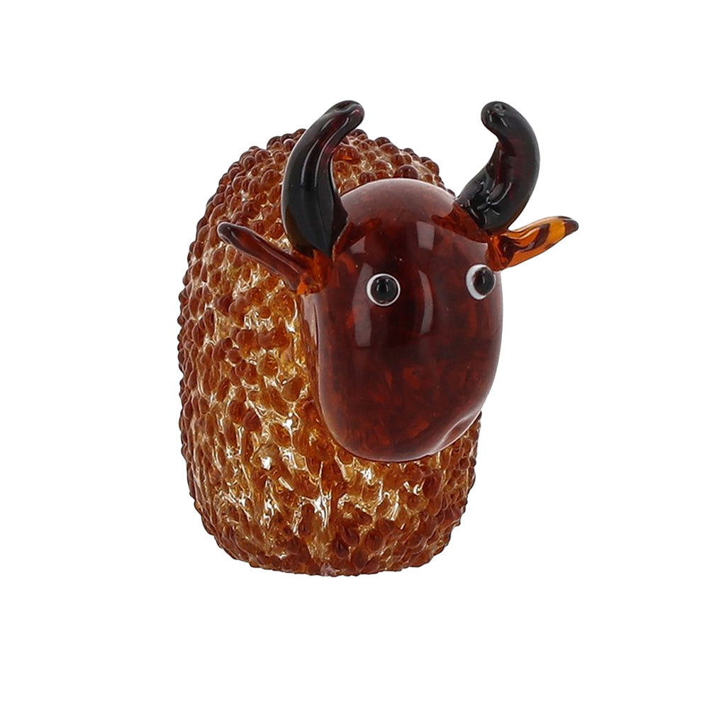 Handmade glass Highland cow ornament with textured amber body and dark curved horns, front view.
