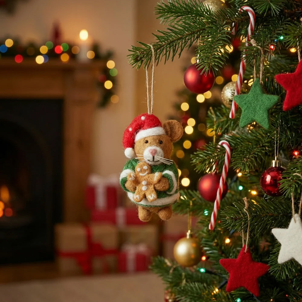 Harvey the Christmas Hamster felt decoration hanging on a Christmas tree with festive lights in the background.