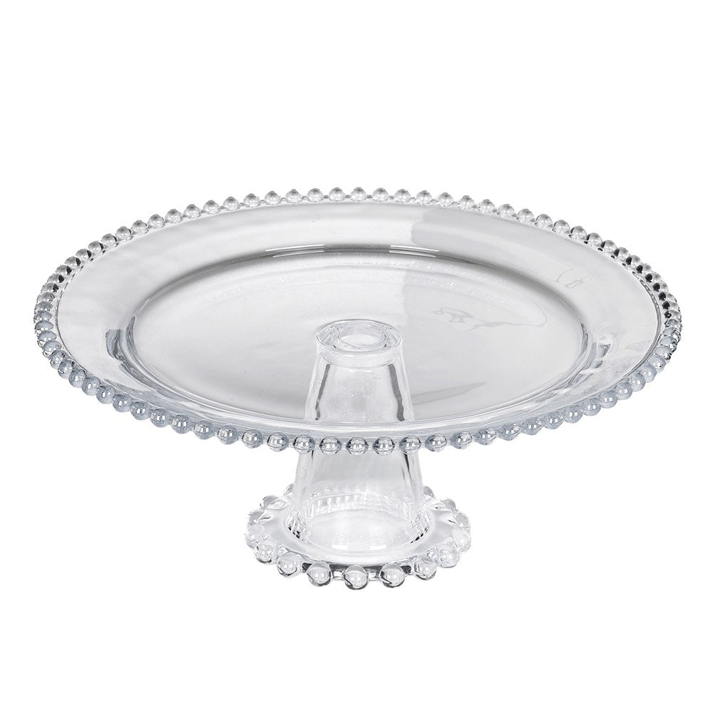 Clear glass pedestal cake stand with beaded edge detailing on a white background