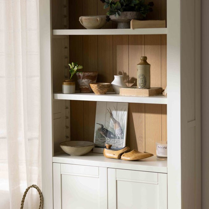 Detail shot of the Burford storage bookcase shelves filled with decorative vases and artwork