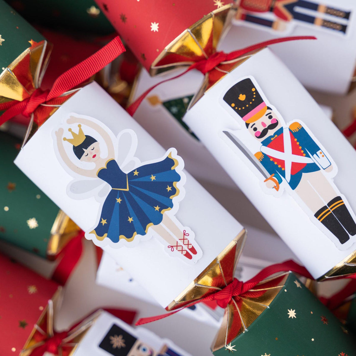 Close-up of handmade Christmas crackers showing a ballerina and Nutcracker soldier illustration.