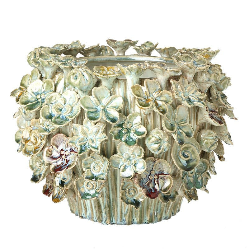 Front view of the large floral decorative pot showing the detailed sculpted ceramic flower patterns.