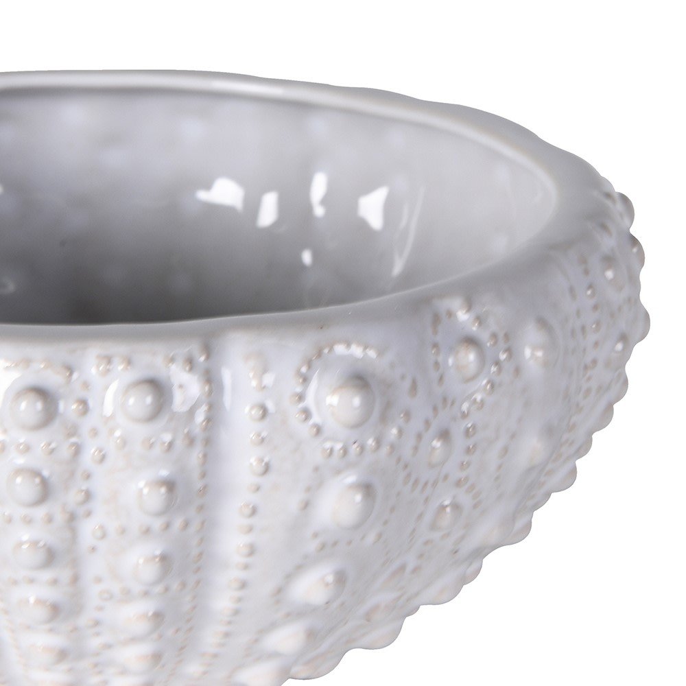 Close-up of the raised urchin texture and glossy white glaze on a ceramic bowl