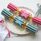Close up of red and teal striped crackers with gold scalloped detailing and bow accents.