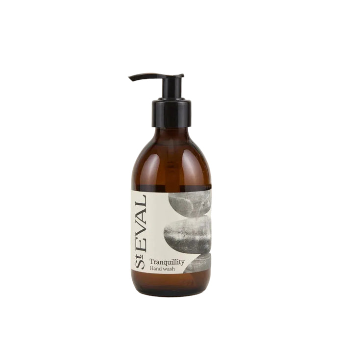 Amber glass hand soap bottle with a black pump dispenser and minimalist stone illustration label.