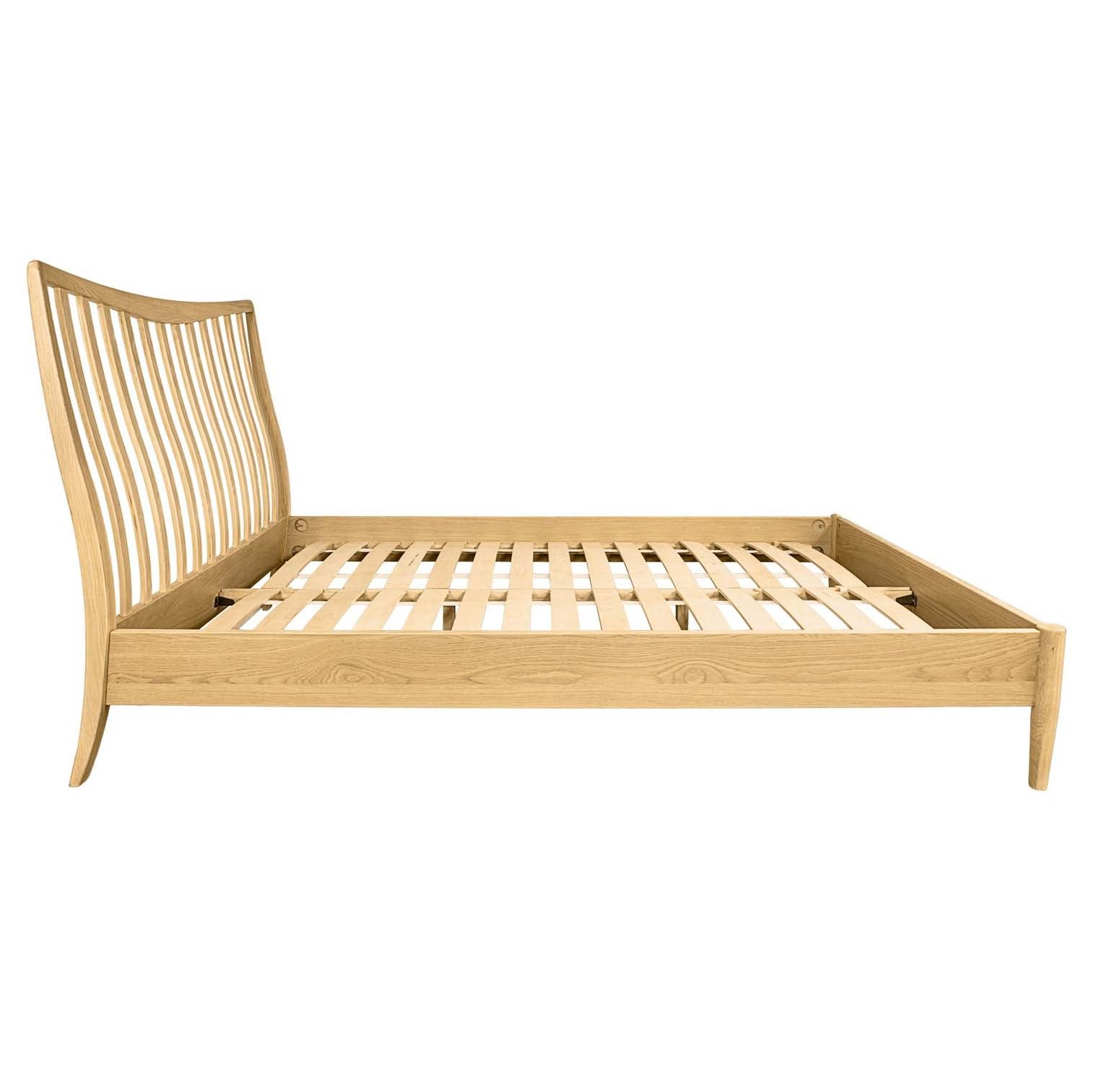 Side profile of the light oak bed frame showing tapered legs and low footboard