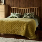 Detailed view of the G Plan Larsen bed headboard styled with palm print pillows