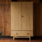 G Plan Larsen wardrobe styled against dark wood walls in a modern interior
