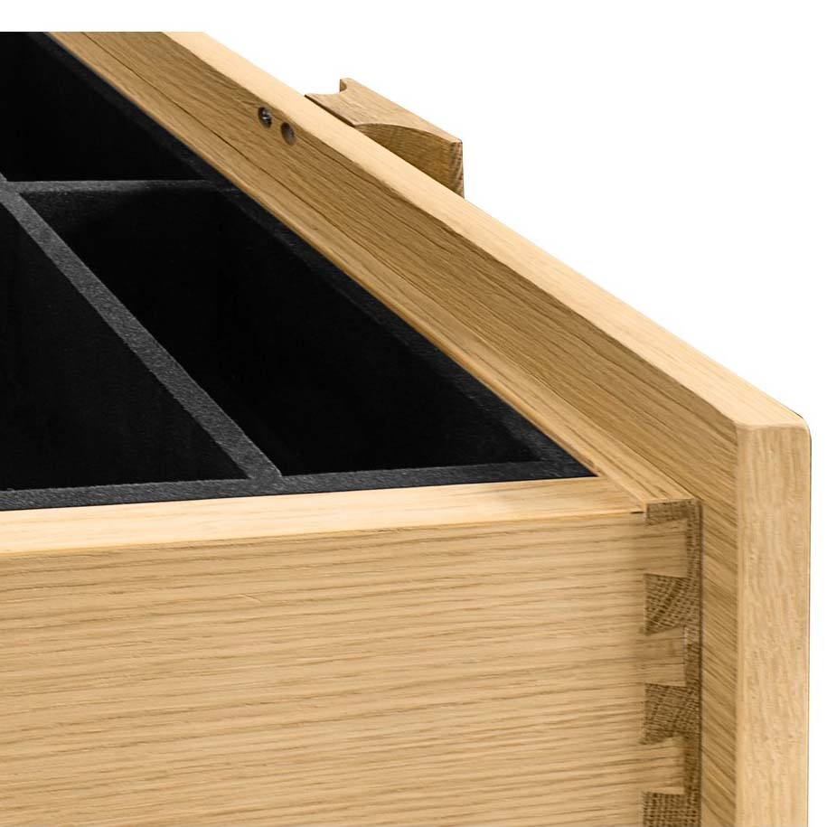 Interior detail of an open drawer showing black felt-lined compartments and high-quality dovetail joinery.