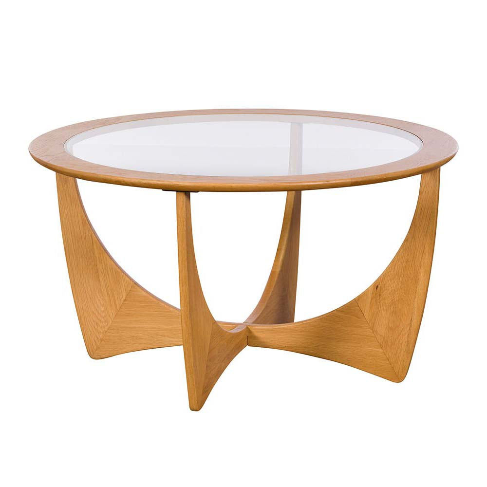 G Plan Larsen round oak coffee table with sculptural base and glass top on a white background