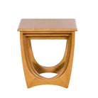 Side profile of the nested oak tables highlighting the elegant arching wooden frame and grain.