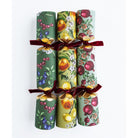 Top-down view of three fruit-themed Christmas crackers showing detailed pomegranate and citrus patterns.