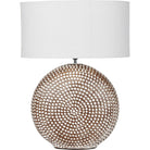 Front view of the Chariot ceramic lamp with round textured base and ivory oval drum shade