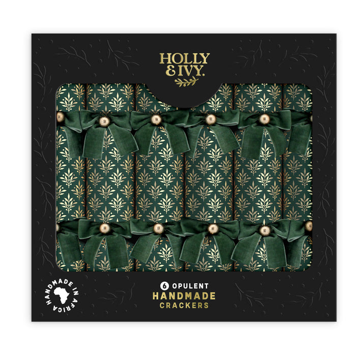 Box of six green and gold Christmas crackers with velvet bows in a black presentation box.