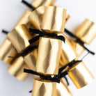 A cluster of gold petite Christmas crackers showing the embossed diamond texture and velvet ties.