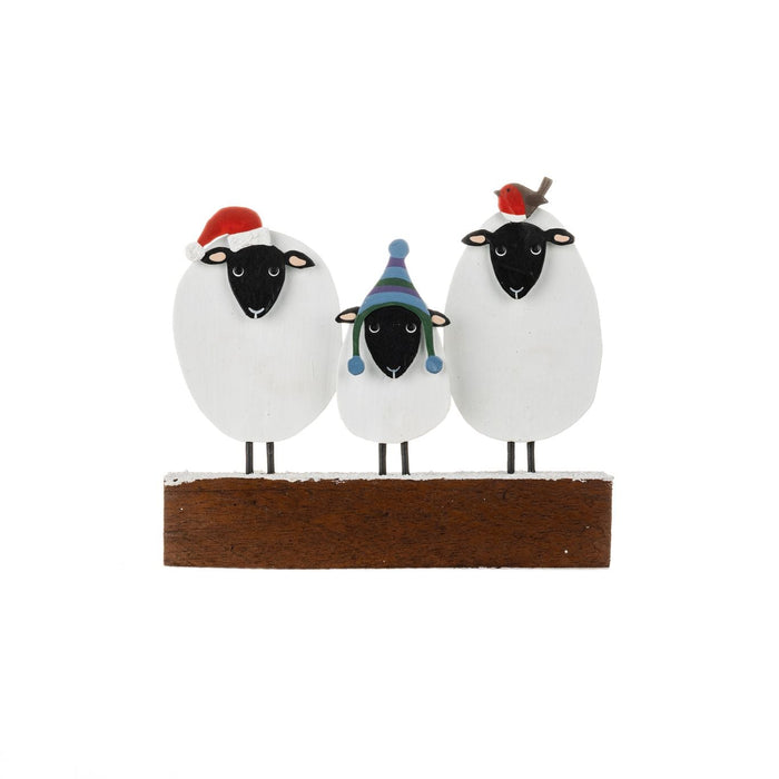 Three hand-painted metal sheep in festive hats and a robin, standing on a snow-dusted wooden base.