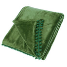 Folded dark olive fleece throw with decorative pom-pom braid trim on a white background.