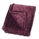 Folded mulberry fleece throw with a decorative pom-pom braid edge on a white background.