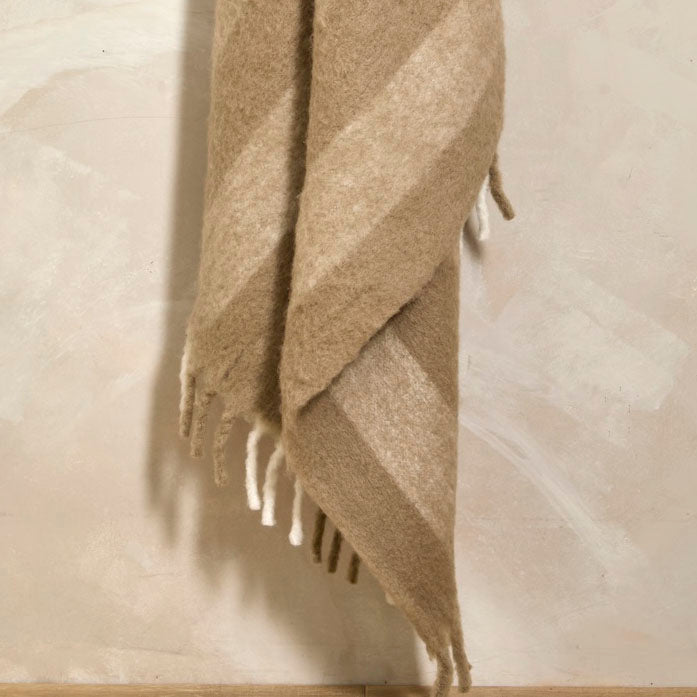 Close-up of the birch stripe wool blend throw draped to show texture and fringing