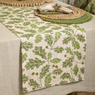 Acorn and oak leaf print linen table runner styled on a neutral tablecloth with rustic place settings.