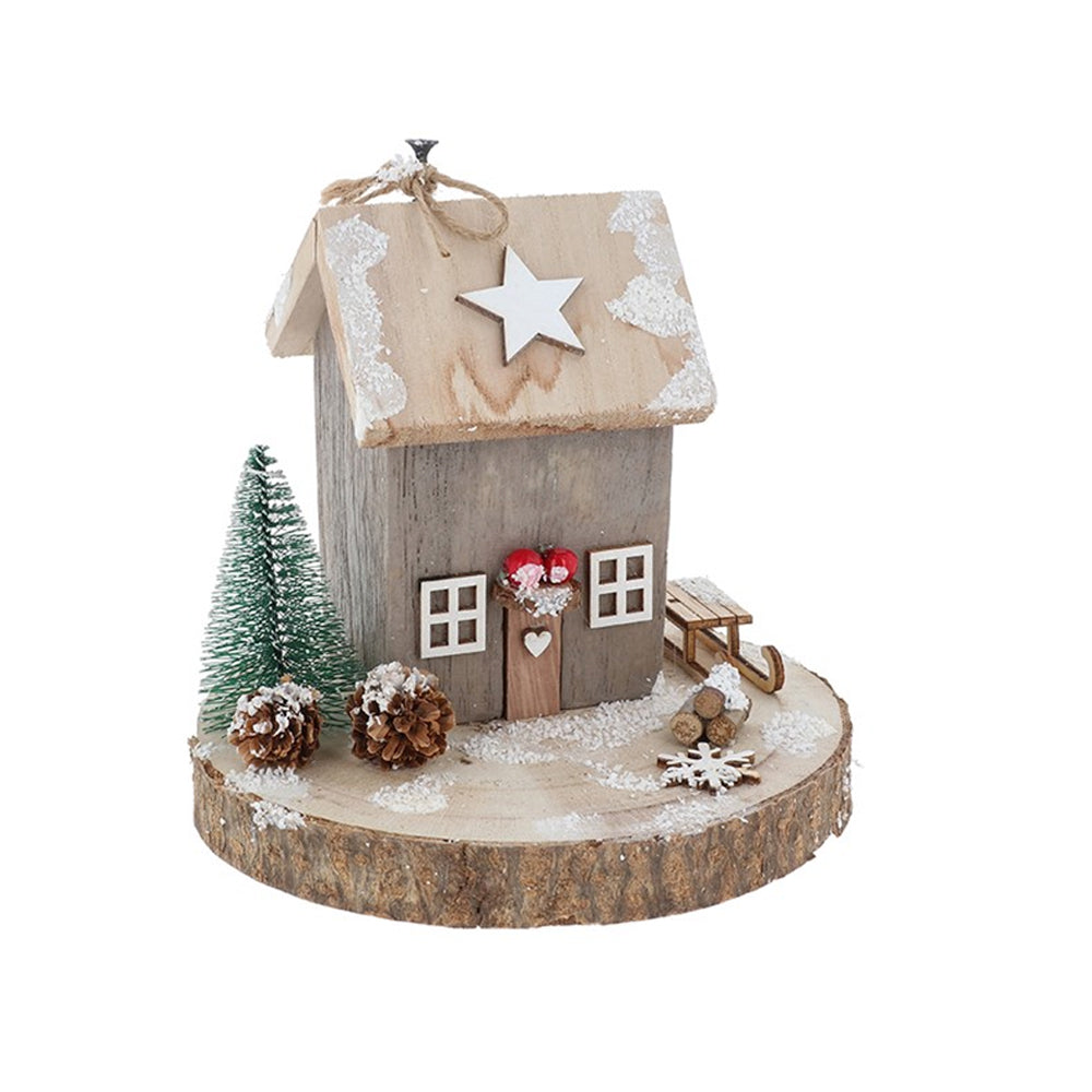 Grey wooden Christmas cottage decoration with pine cones and a miniature sled on a rustic log base