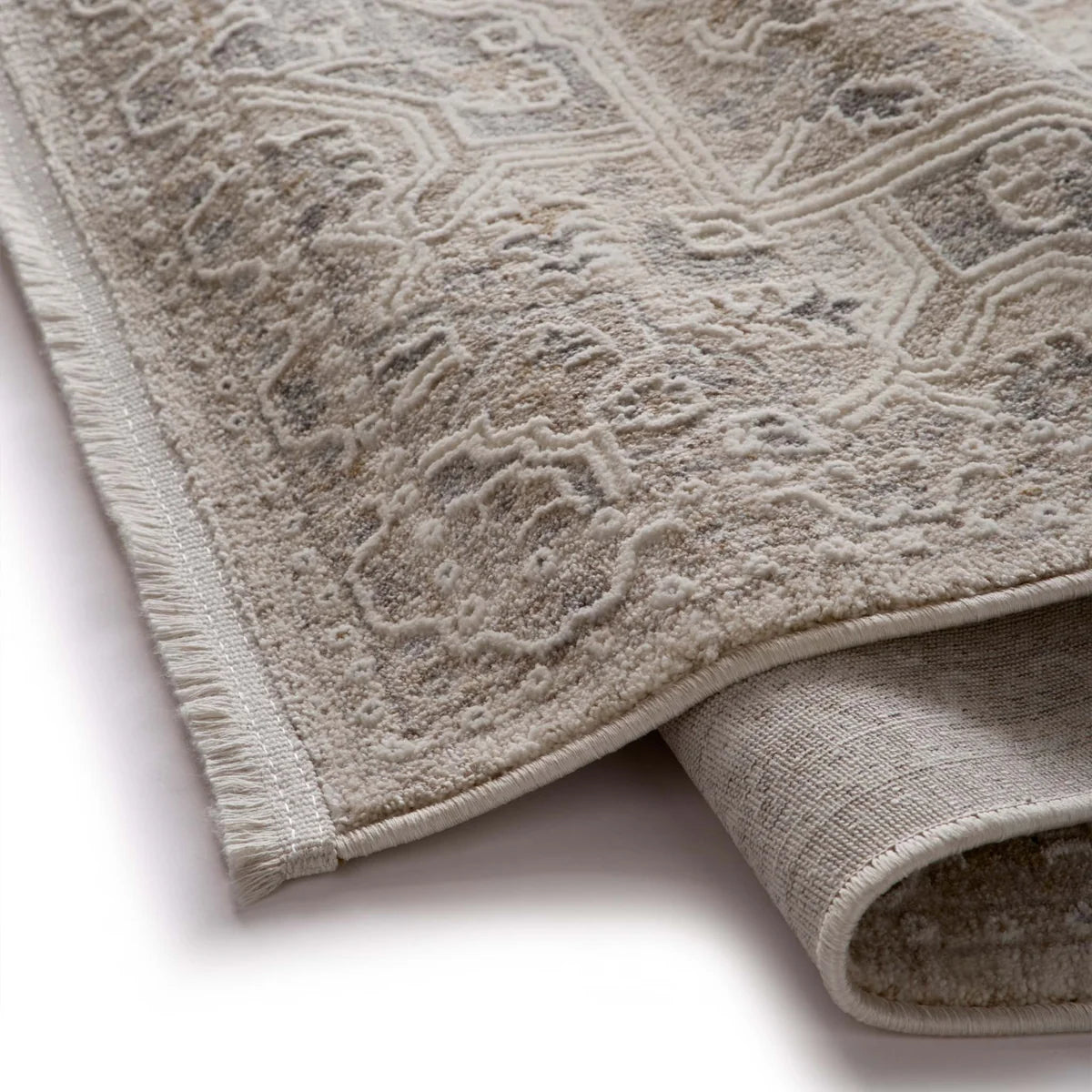 Detail view of the rug corner showing the short fringe and the underside of the weave.