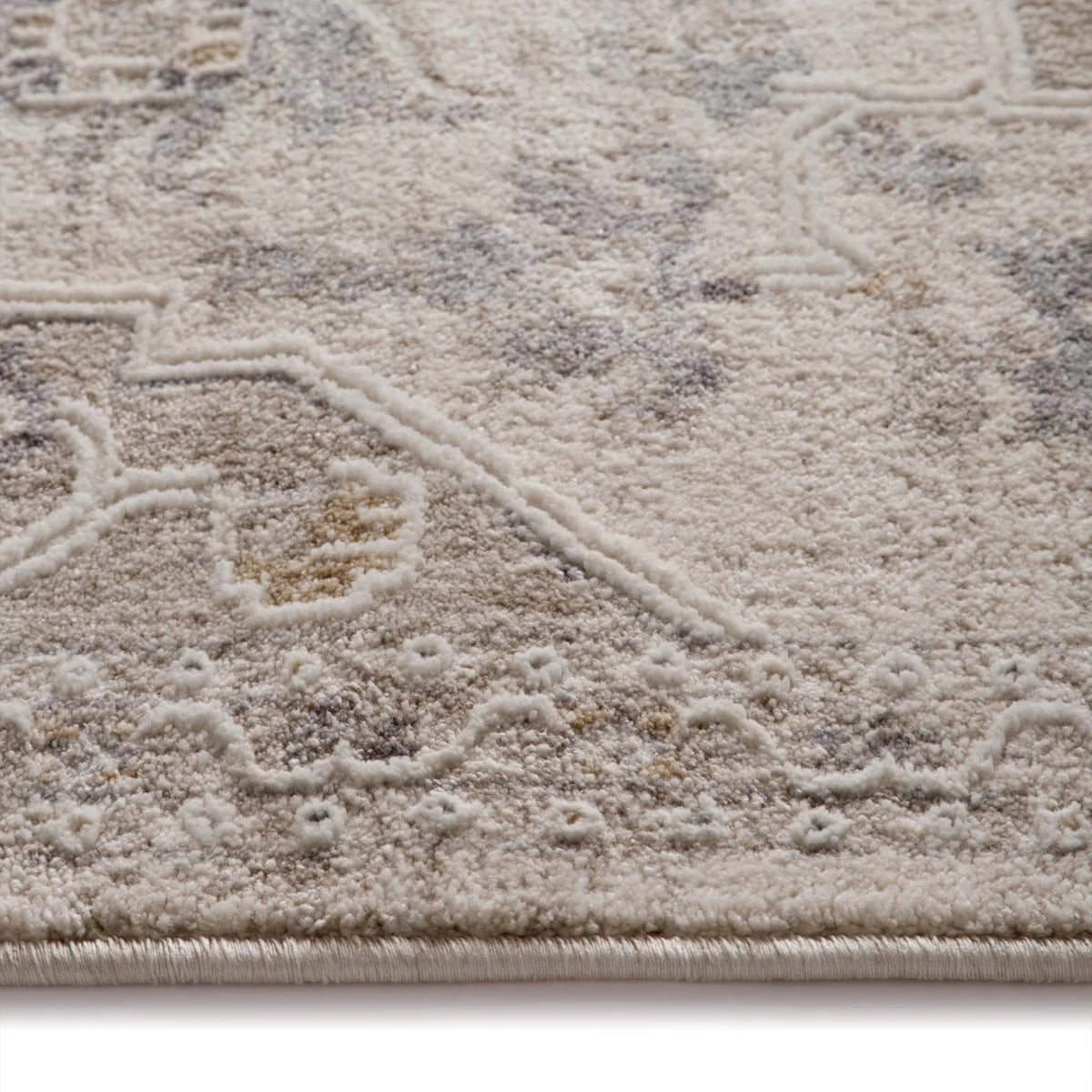 Close-up of the distressed polyester yarn texture and raised geometric pattern details.