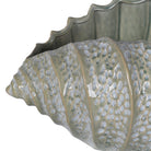 Close-up of the celadon green ceramic shell showing the detailed surface texture and crackle-effect glaze.