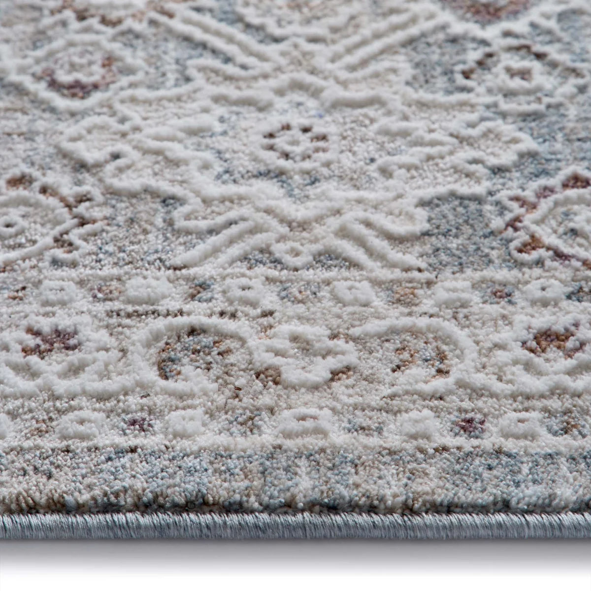 Close-up of the Celeste Sea Green rug texture showing the raised pile and distressed ivory floral details.