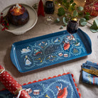 Festive table setting featuring the 12 Days of Christmas tray with a glass of wine and Christmas pudding.