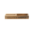 Wooden mobile phone stand and organiser tray engraved with 'DADDY'S THINGS' on a white background.