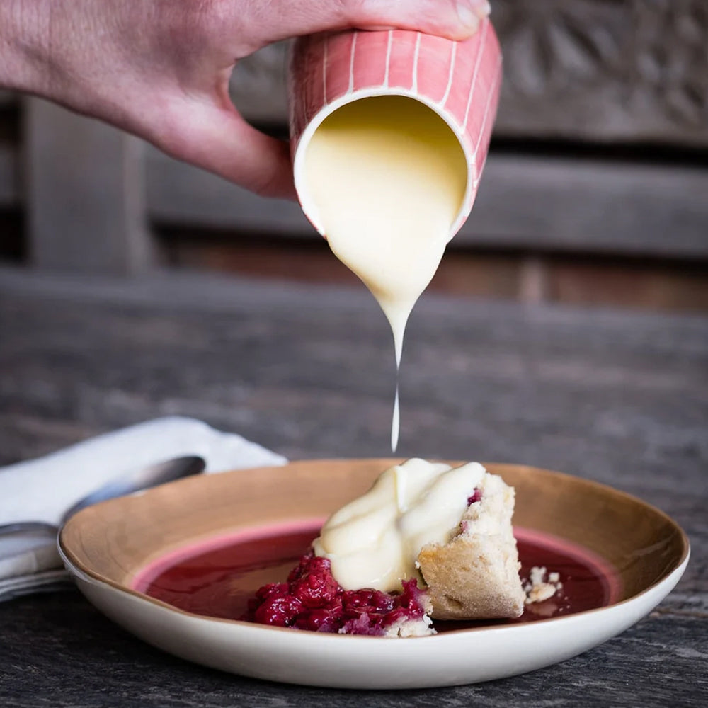 Desert Tri-Colour Plate styled with a portion of fruit crumble and custard being poured from a matching jug.