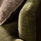 Detail shot of the rounded sofa arm and olive green fabric texture