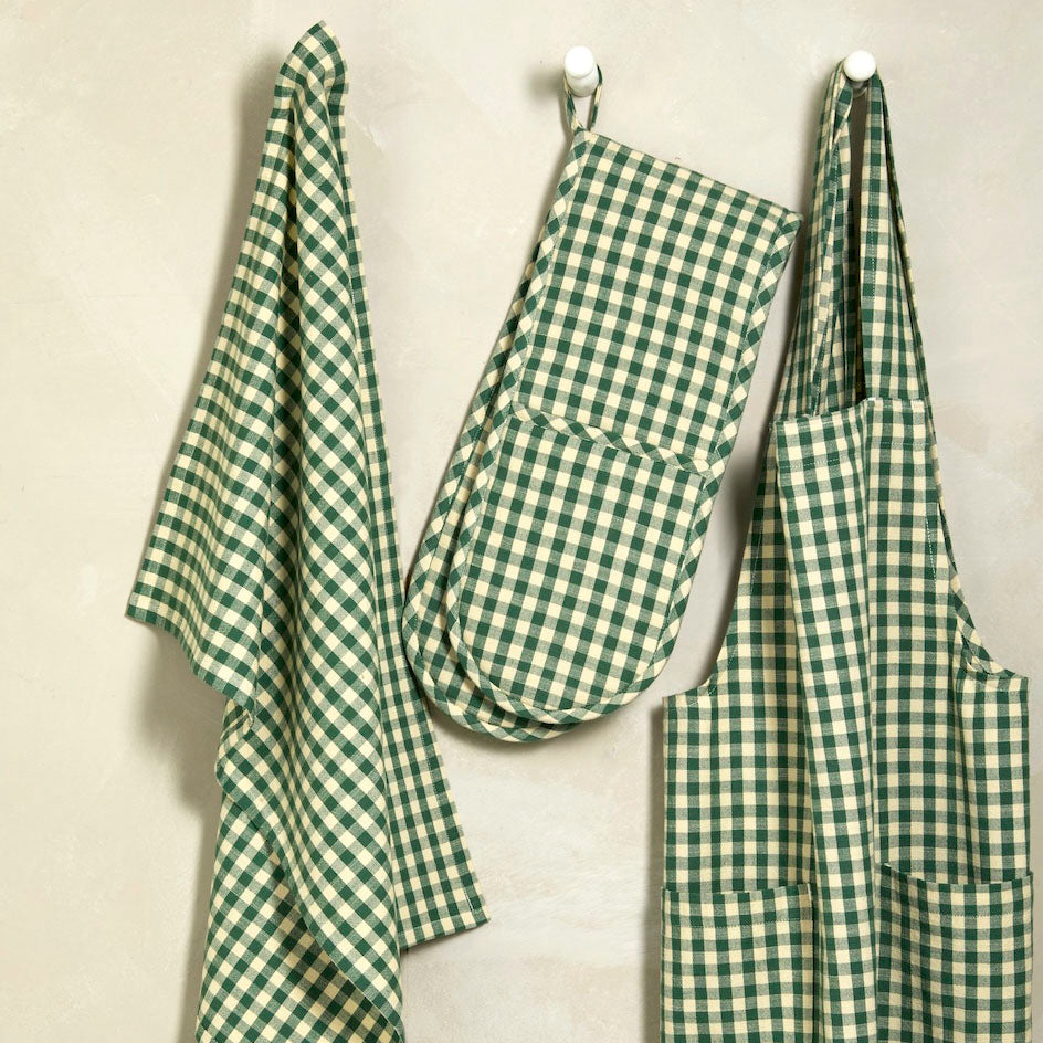 Foliage green gingham kitchen set including an apron, double oven glove, and tea towel hanging on hooks