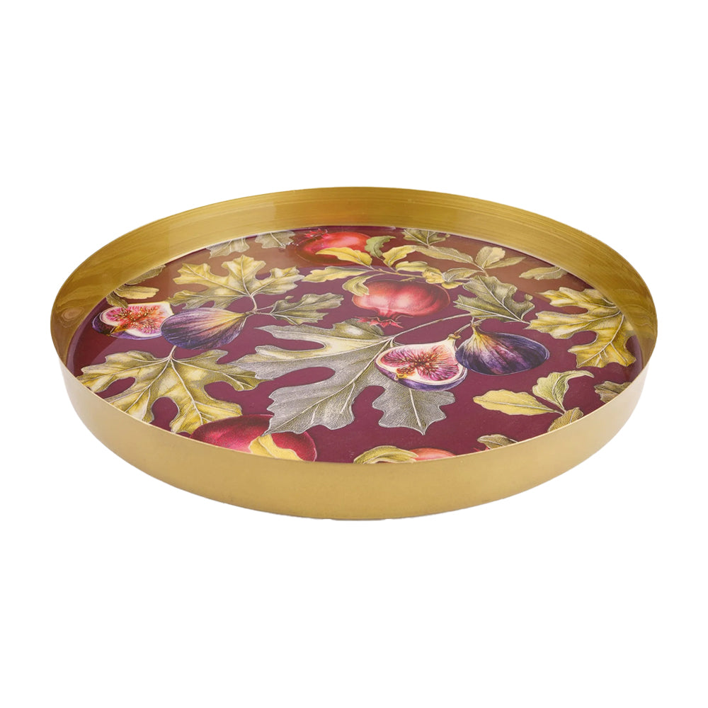 Round gold metal tray showing the raised rim and botanical fig and pomegranate design against a burgundy background.