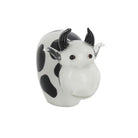 Handmade glass cow ornament with black spots and small black horns on a white background