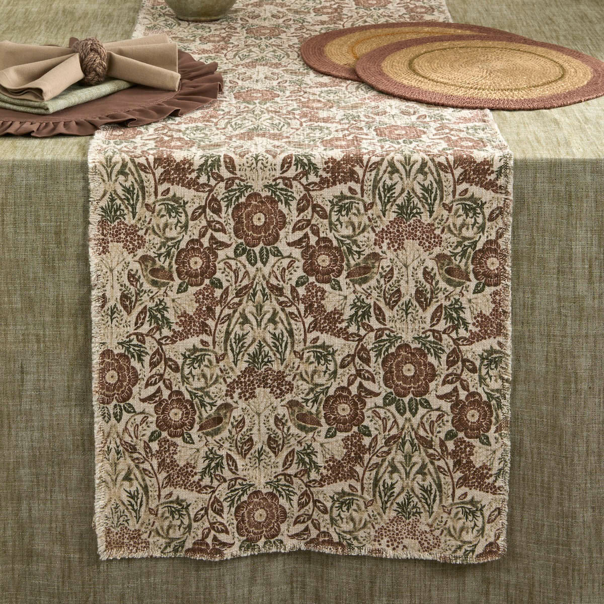Jenny Wren table runner draped over a rectangular dining table alongside neutral napkins and placemats.