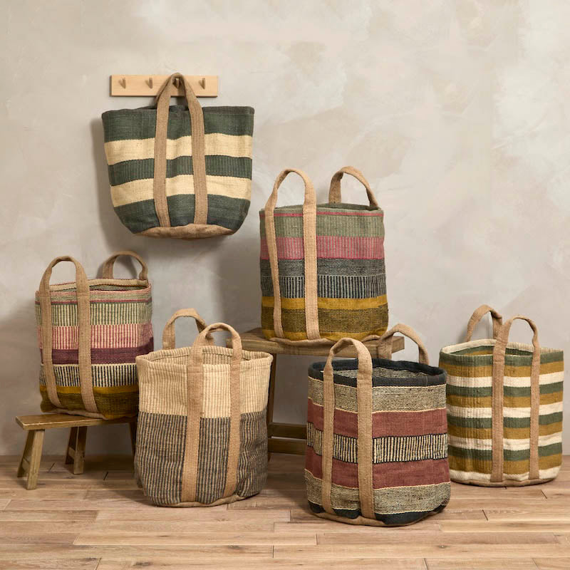 A collection of various striped jute storage baskets in different earthy colours styled in a room setting.