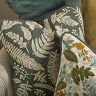Close-up of the tactile cream embroidery on the eucalyptus cotton Kew cushion, layered with other textiles.
