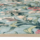 Close-up of the soft blue floral rug texture and stitched edge