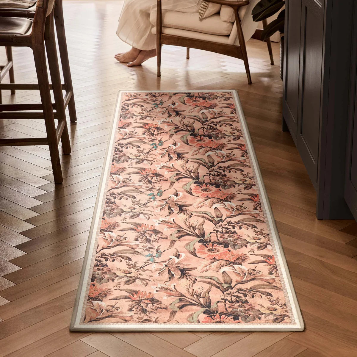 Lys Pink runner rug styled in a hallway on a wooden herringbone floor.