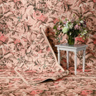Lys Pink rug draped beside a side table with a flower vase, showing the design movement.