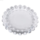 Top-down view of a clear glass candle plate with a decorative beaded circular edge.