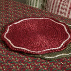 Red scalloped jute placemat styled on a festive patterned tablecloth alongside a green variant.