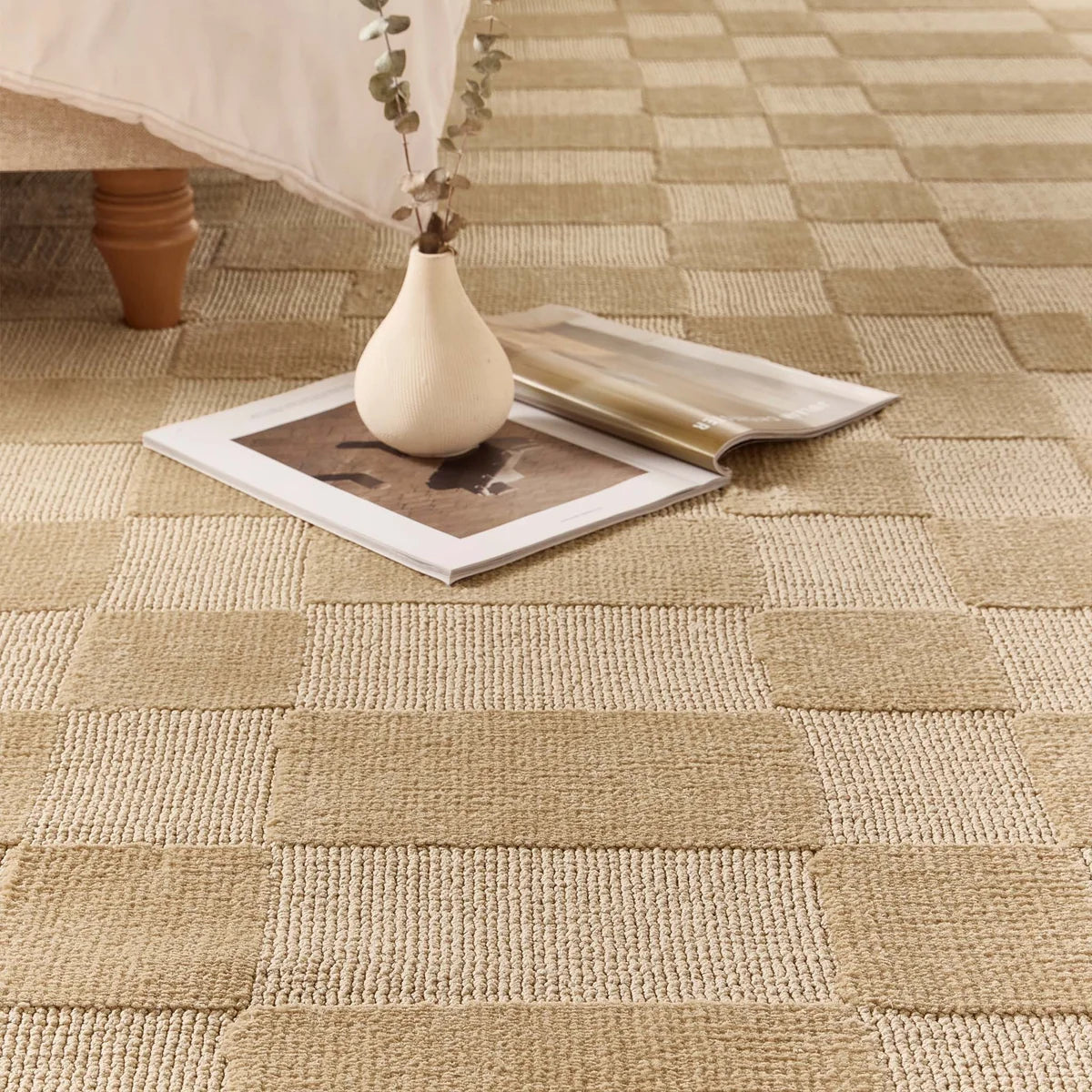 Detail shot of the Soho Beige rug styled with a vase and magazine, showing the depth of the textured pattern.