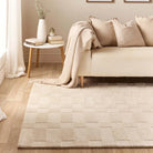 The Soho Ivory Rug styled in a neutral living room setting with a cream sofa and side table.